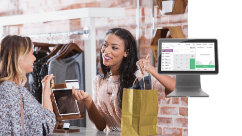 Smiling retail associate handing a customer a bag while using a Loyallty and Marketing system